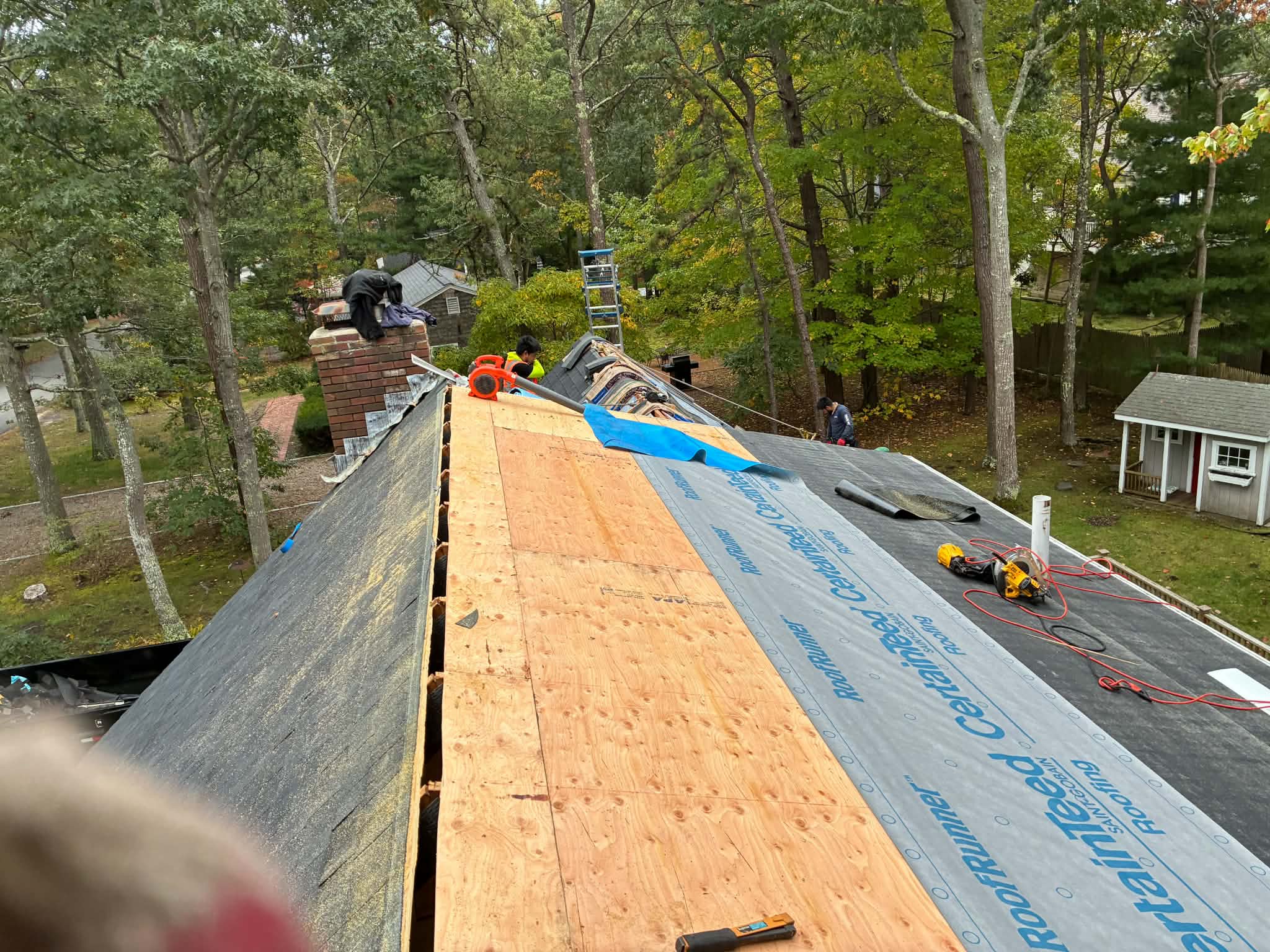 Workers installing roofing underlayment